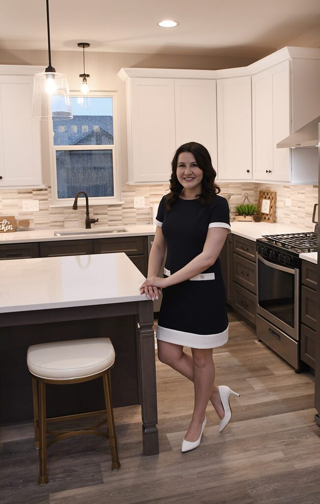 A woman standing in front of a kitchen island.