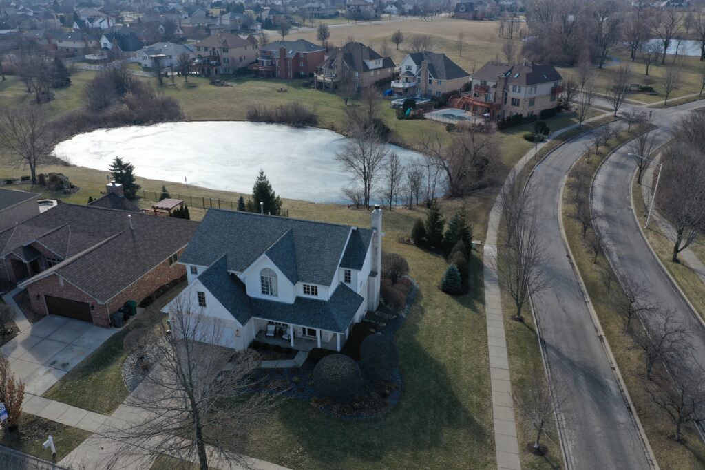 An aerial view of a house and a pond.