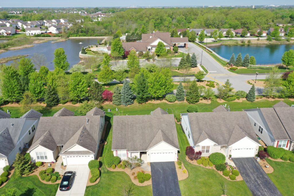 An aerial view of a neighborhood with houses and a lake.