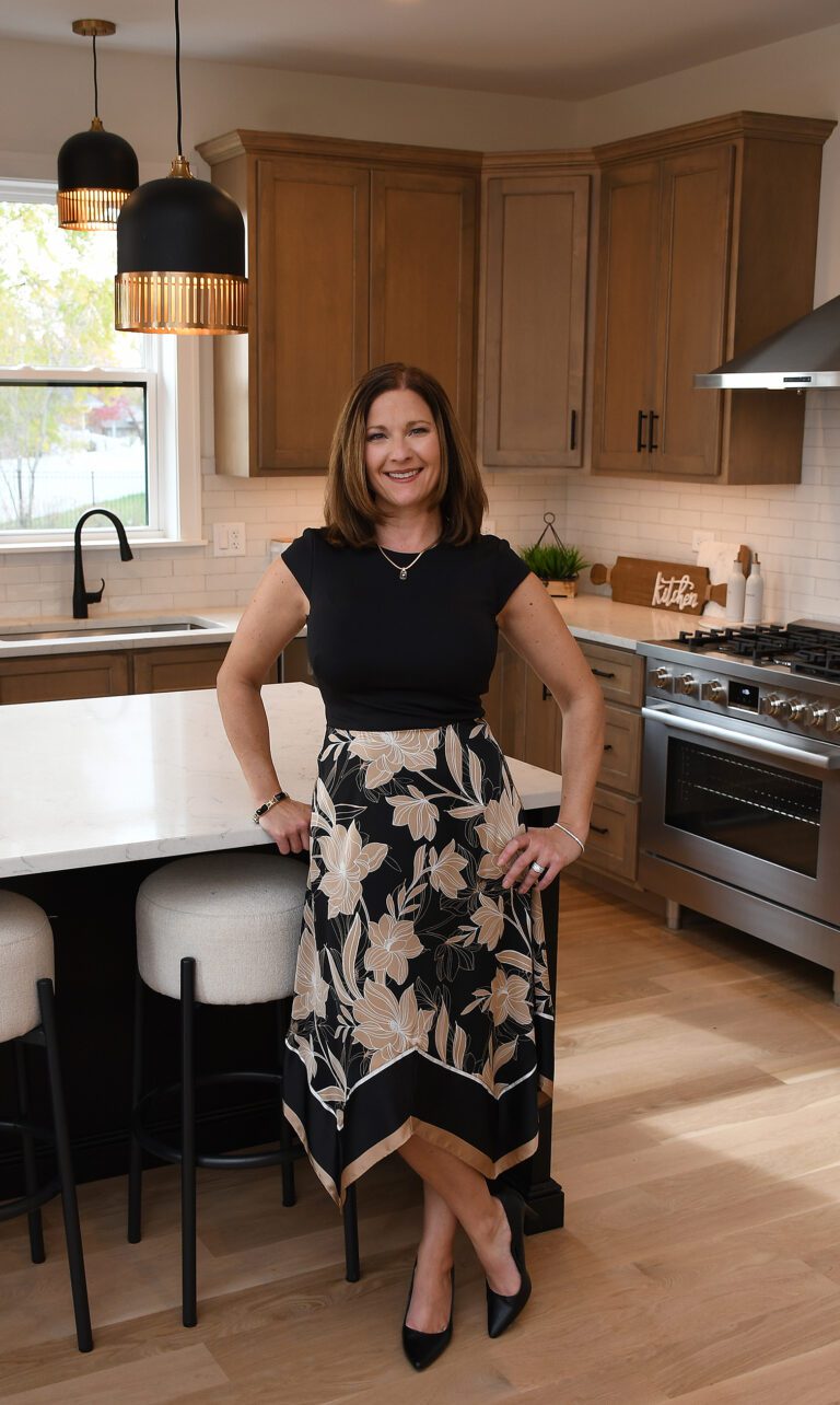 A woman standing in front of a kitchen island.