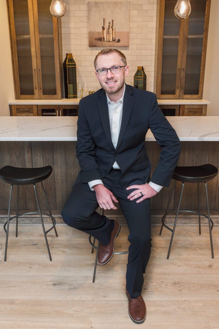 Man in suit sitting at bar counter.