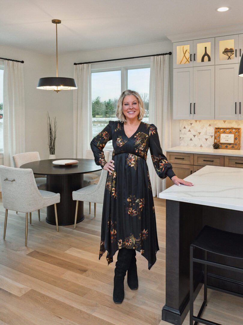 Woman in floral dress in modern kitchen.